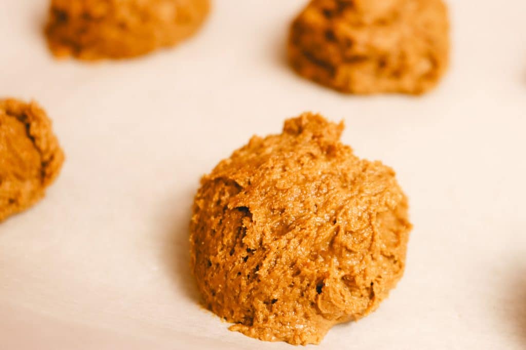 scoops of ginger cookie dough on parchment paper