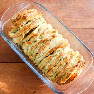 pull apart bread loaf in a glass bread pan on a wooden counter