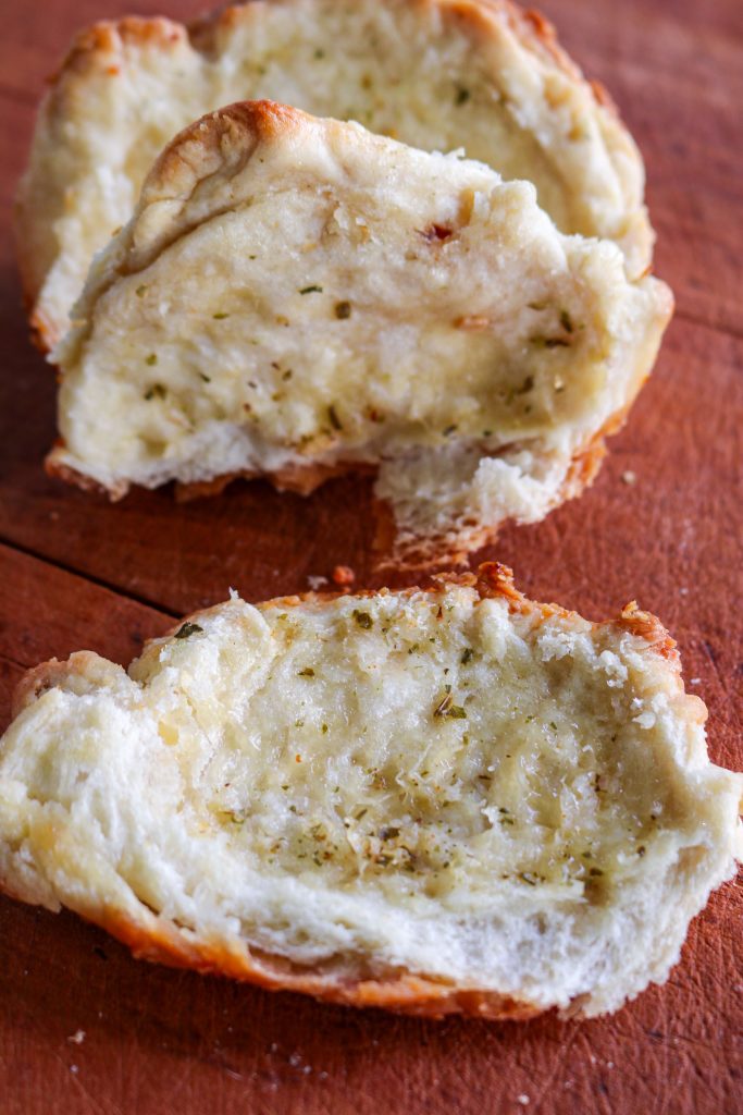 two pieces of pull apart bread on a wooden counter