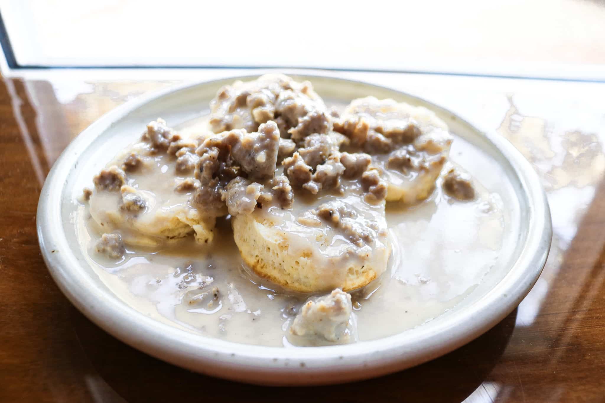 sausage gravy on biscuits on a white plate