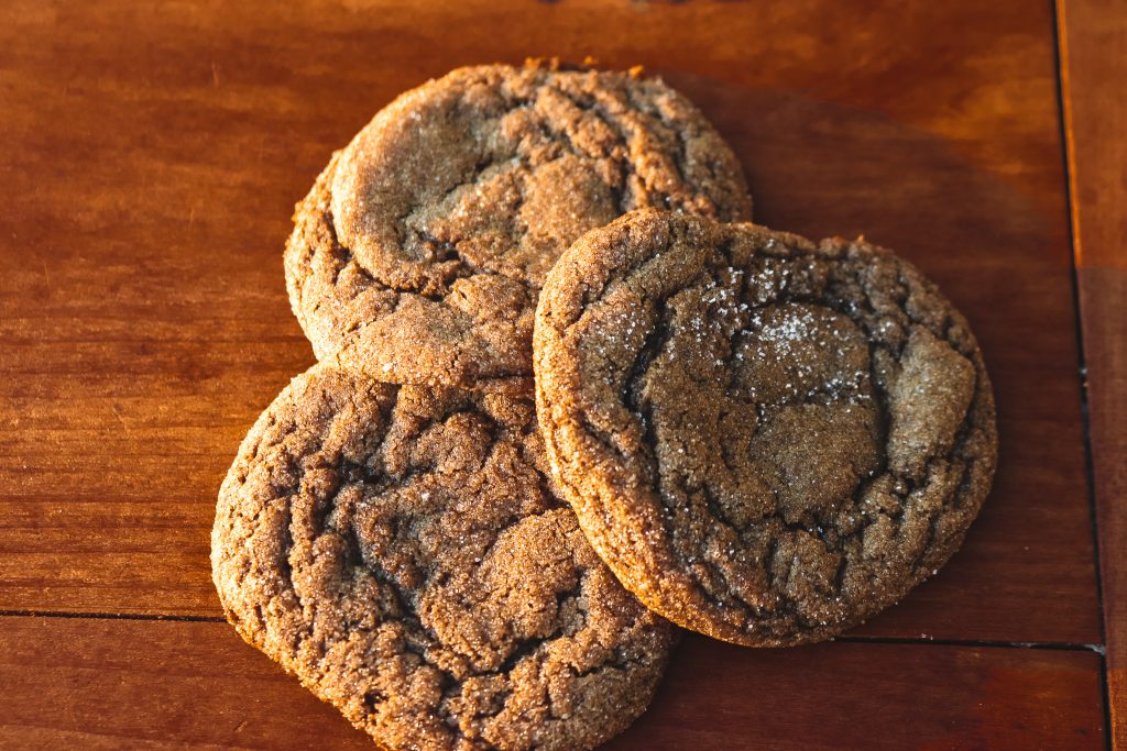 stack of 3 ginger cookies on a wood counter