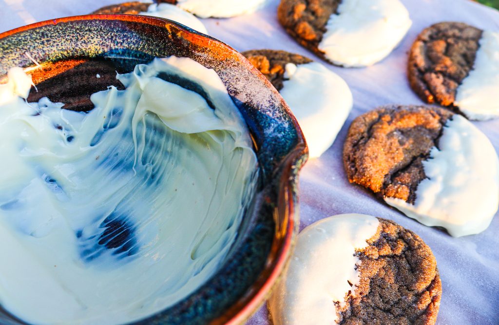 bowl of white chocolate and ginger white chocolate cookies on parchment paper