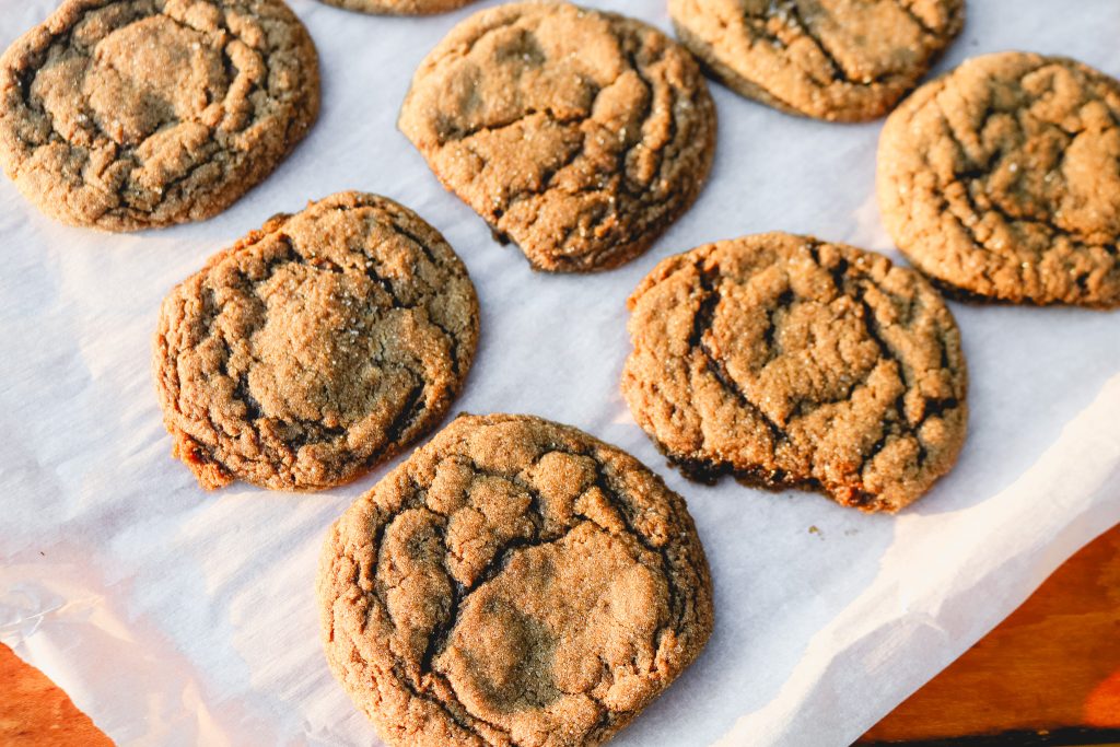 ginger cookies on parchment paper on a wooden counter top