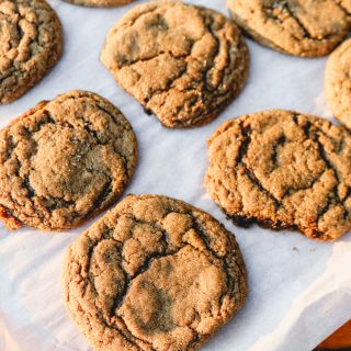 ginger cookies on parchment paper on a wooden counter top