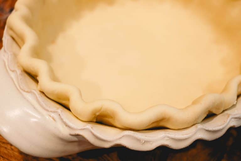 crimped pie crust in a white dish unbaked