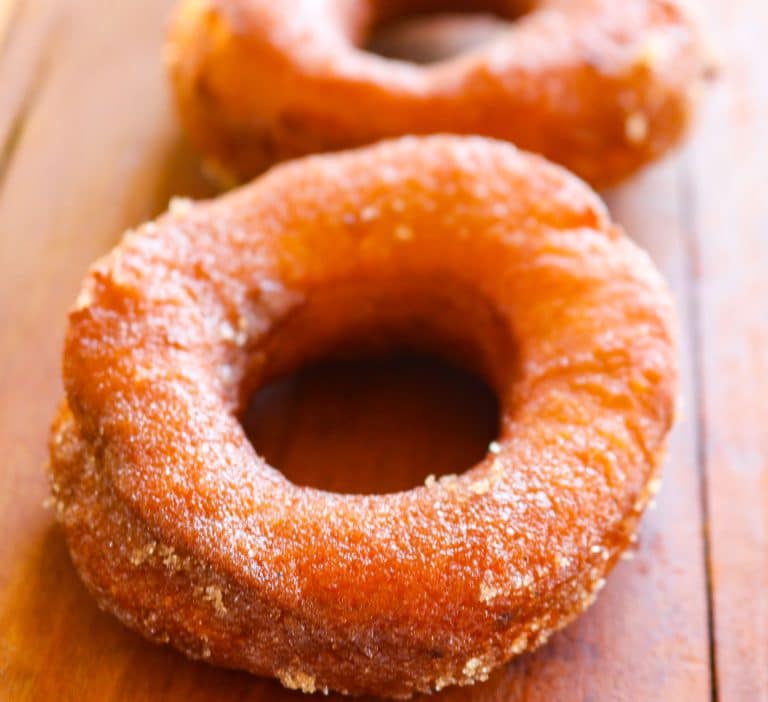 glazed pumpkin donuts on a wooden counter