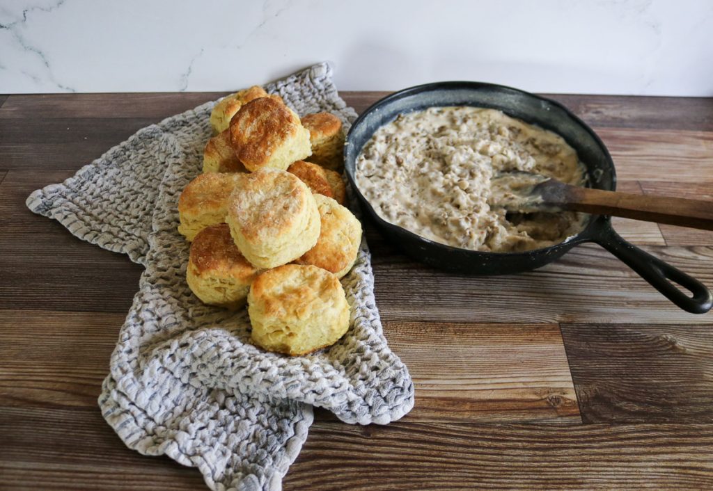 Cast iron skillet of sausage gravy with sourdough biscuits