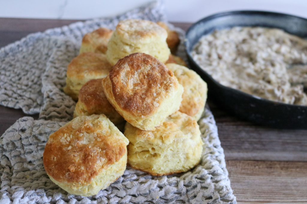 Sourdough biscuits stacked on a tea towel with gravy