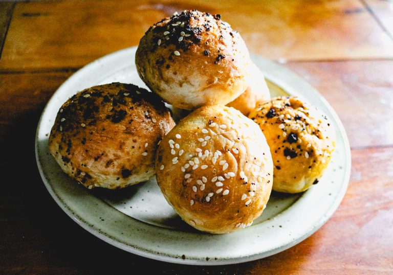 a stack of miniature bagels on a white plate