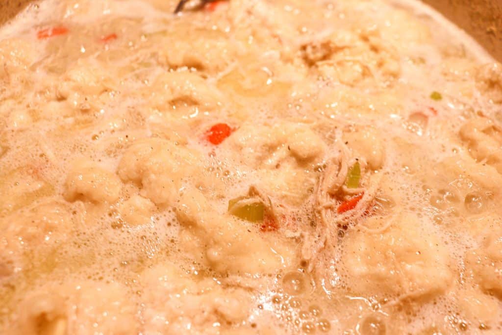 chicken and dumplings boiling in a pot