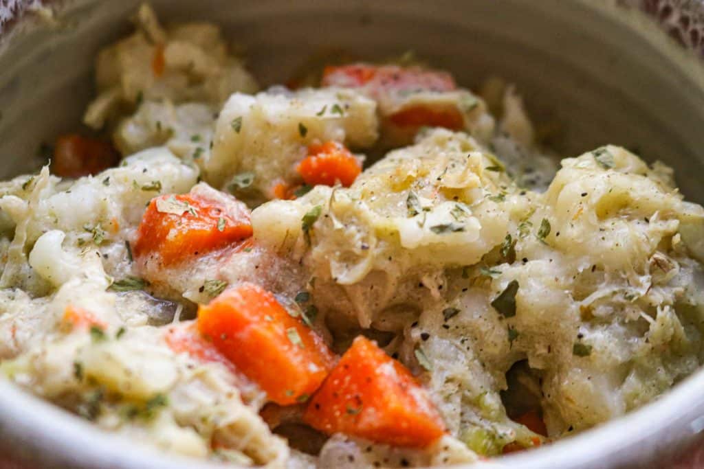 white pottery bowl of chicken and dumplings