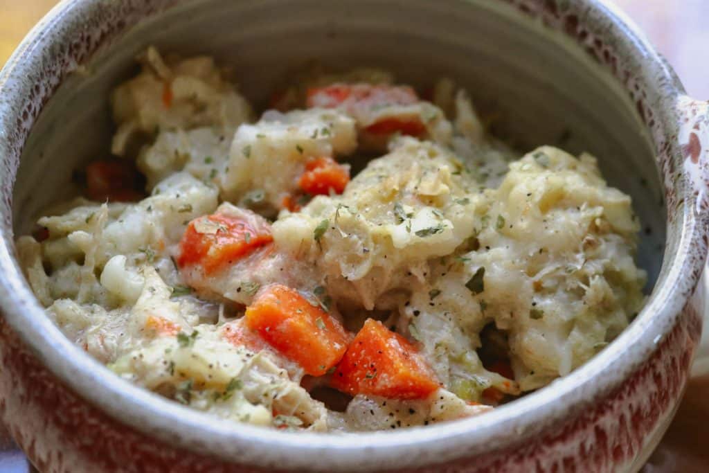 bowl of chicken, dumplings, carrots and parsley