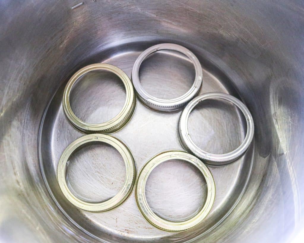 five metal canning rings in the base of an instant pot as a trivet