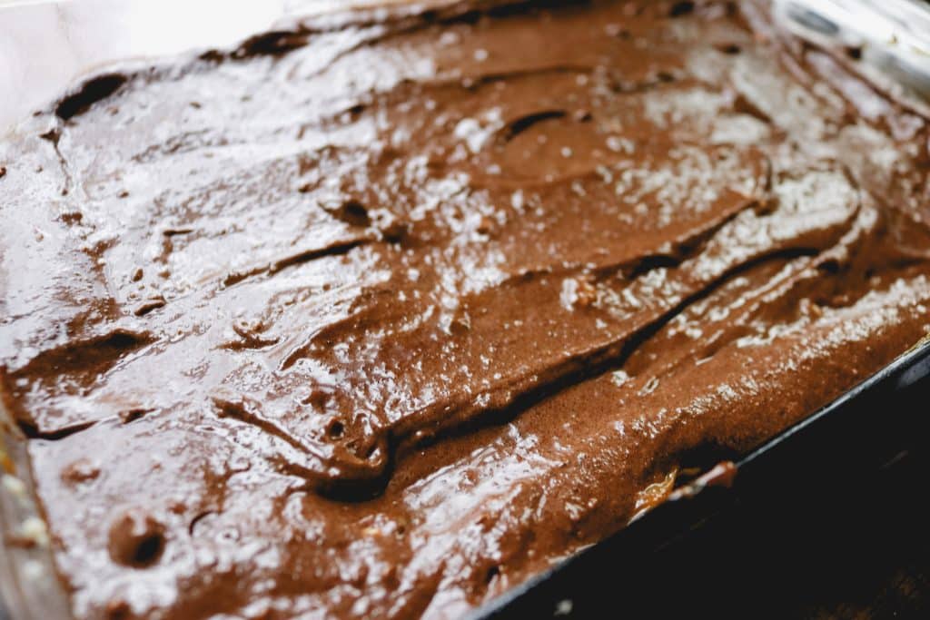 unbaked batter of a chocolate caramel bar spread over the pan