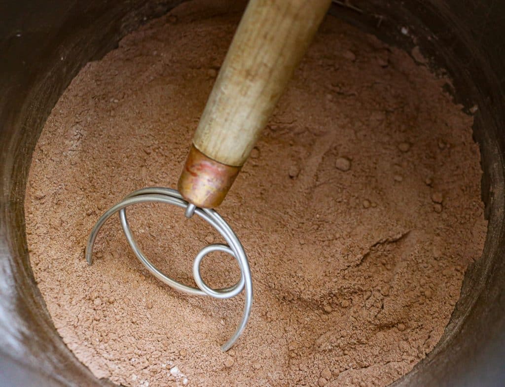 danish whisk in a bowl of dried chocolate pudding mix