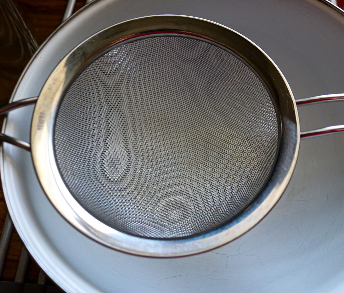 a mesh strainer over a white bowl