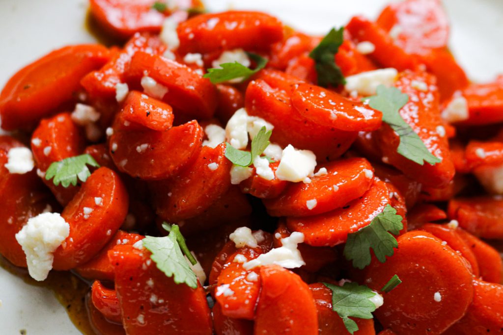 upclose glazed carrots garnished with feta and herbs