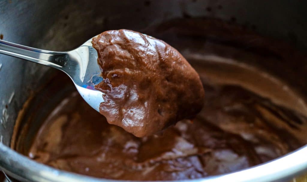 chocolate pudding coating the back of a metal spoon