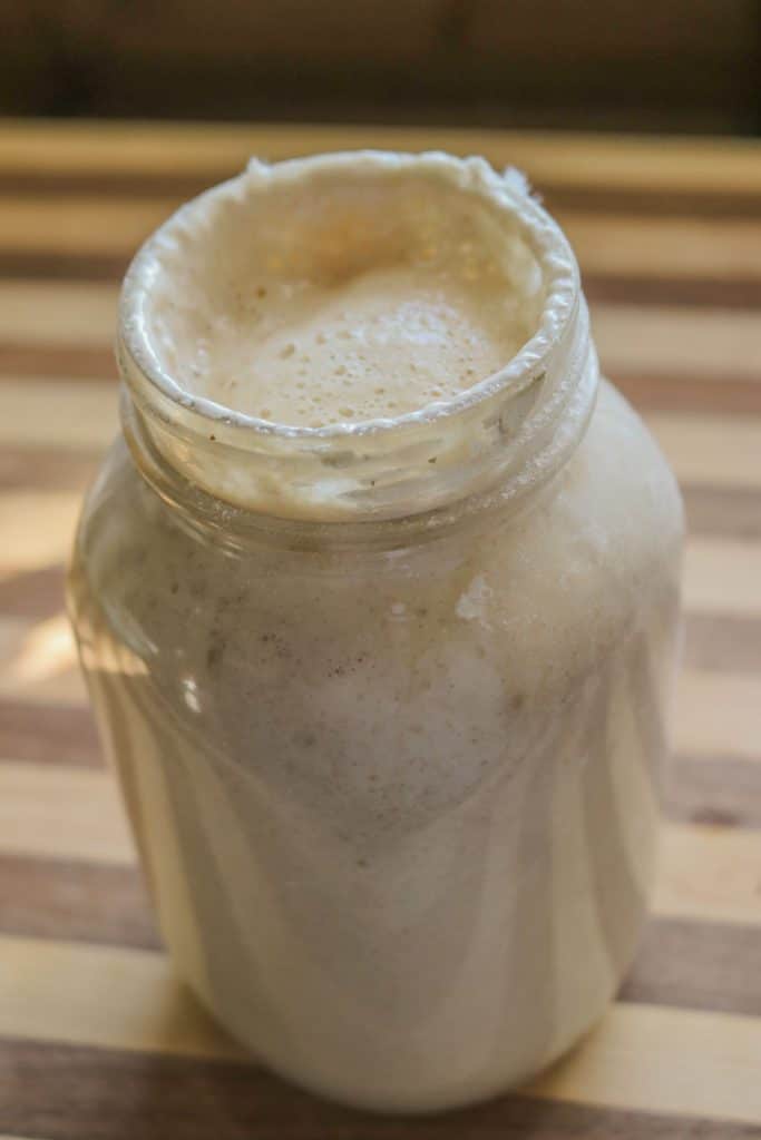 quart sized mason jar full of bubbly active sourdough starter