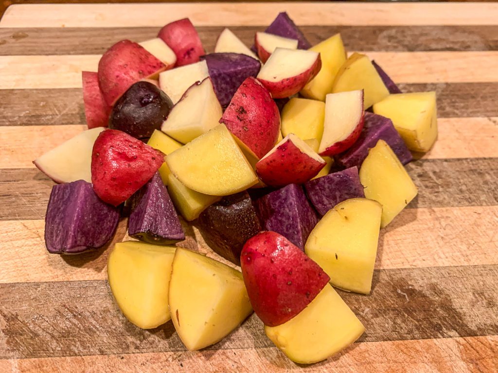 cut colorful potatoes on a wooden cutting board