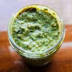 a jar of pesto on a wooden counter