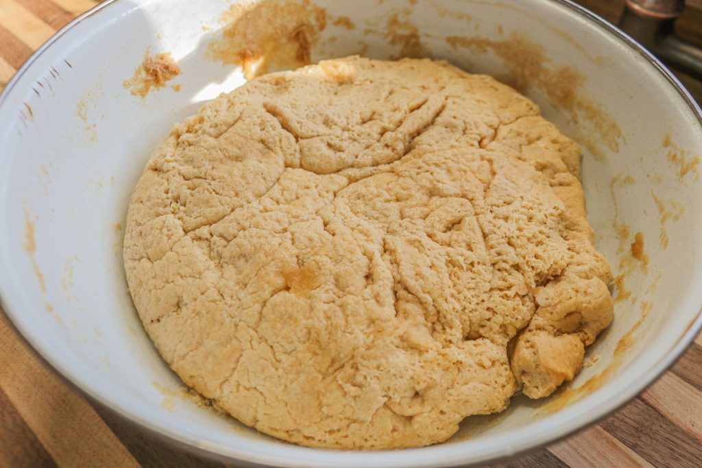 overproofed bread dough in a white bowl