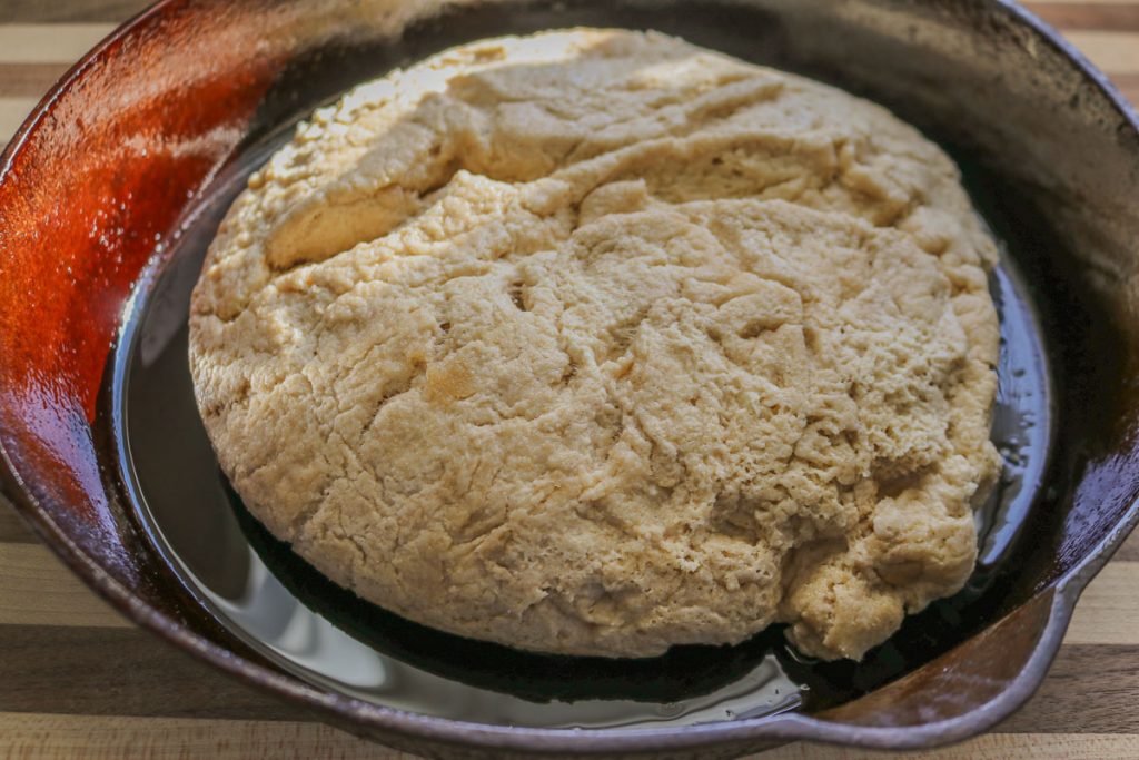 overproofed bread dough in cast iron pan