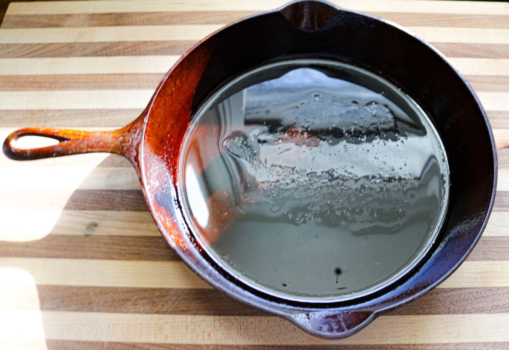 oiled cast iron skillet on a wooden counter