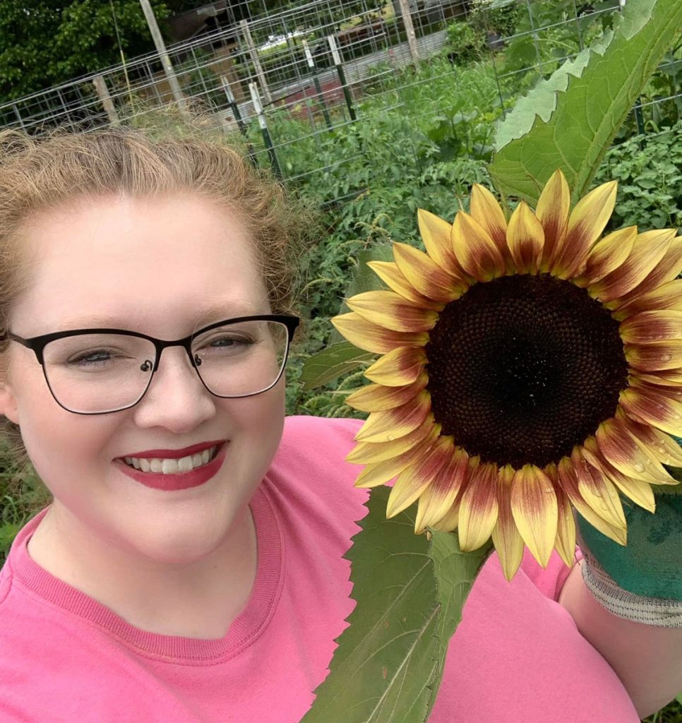 Stephanie holding a red and yellow sunflower