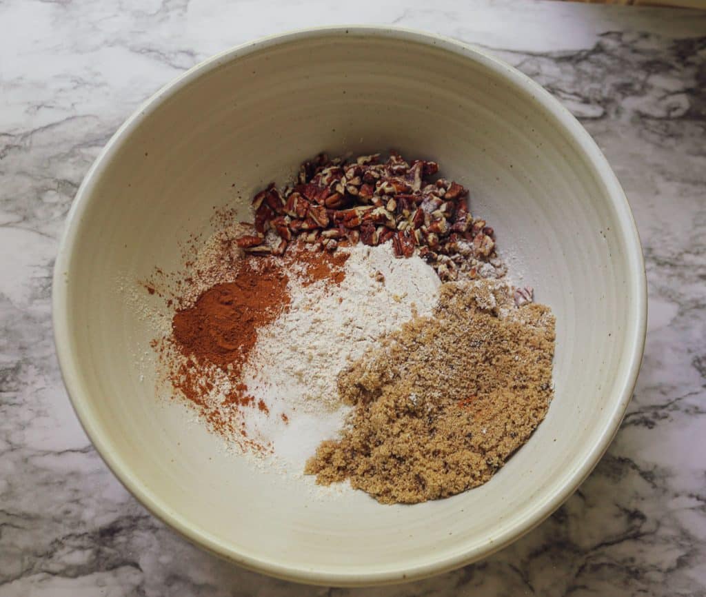 dry ingredients for banana bread in white bowl on a marble counter