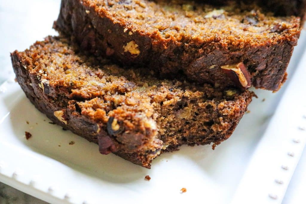 slices of banana bread with bite missing on a white plate