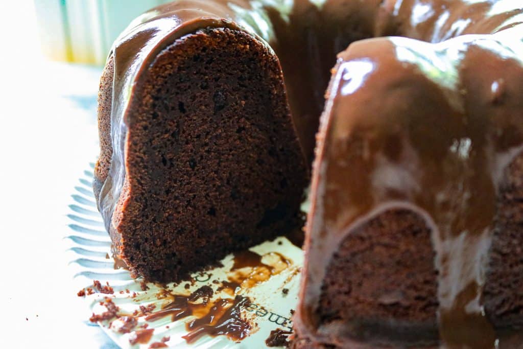 piece missing of a chocolate sourdough bundt cake on a white plate