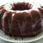 upclose shot of iced sourdough chocolate pound cake on a white plate