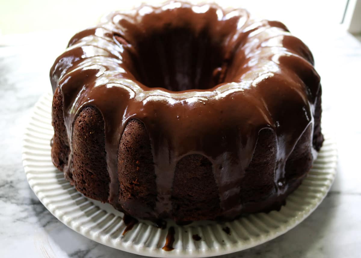 iced sourdough chocolate pound cake on a white plate