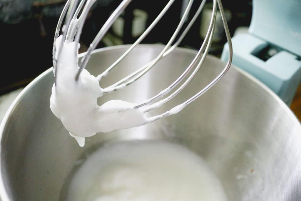 whipped egg whites on the whisk of a kitchenaid mixer