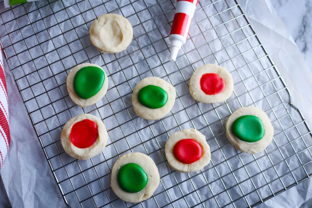 red and green thumbprint cookie on a wire rack