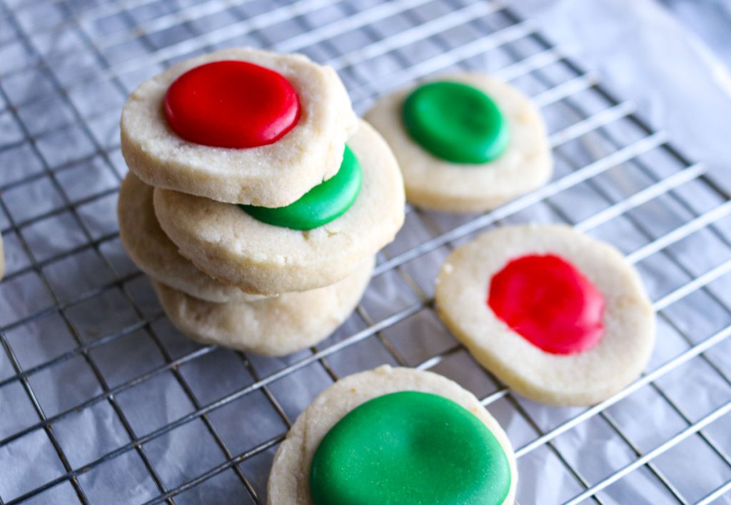 stack of red and green thumbprint cookies on a wire rack