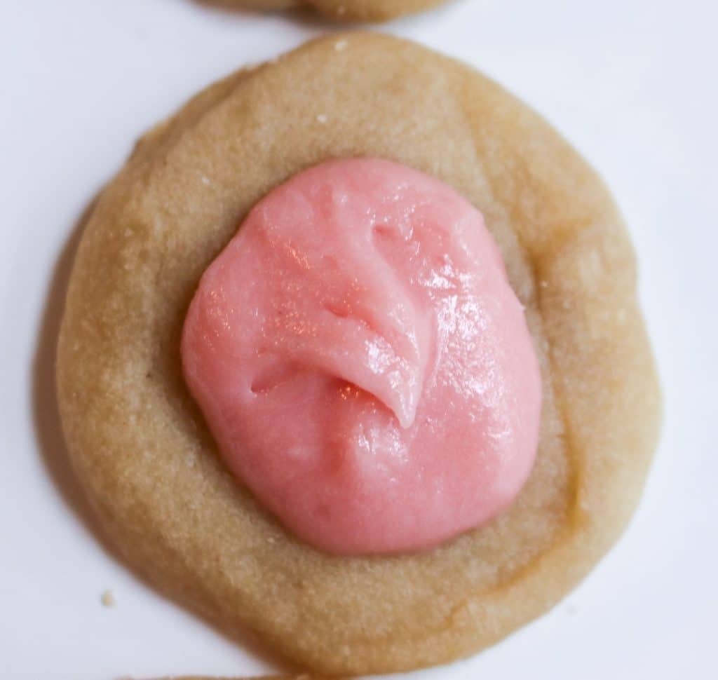 a small bite sized sourdough shortbread tea cookie with pink icing
