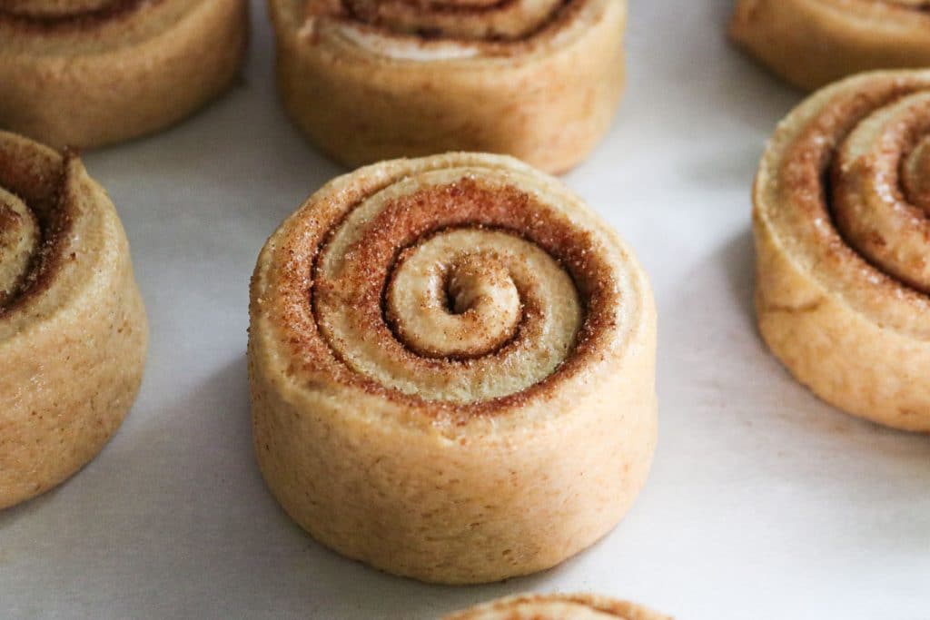 cinnamon roll on a parchment lined tray