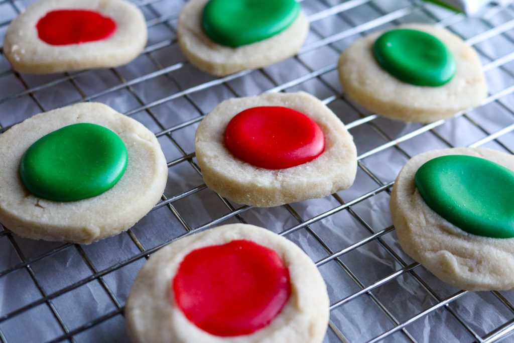 red and green thumbprint cookie on a wire rack