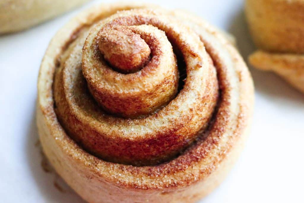 cinnamon roll on a parchment lined tray