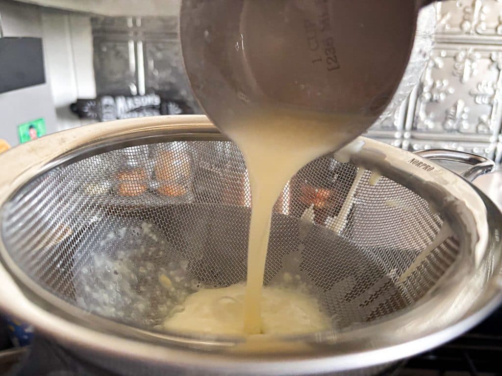 straining custard through a fine mesh seive