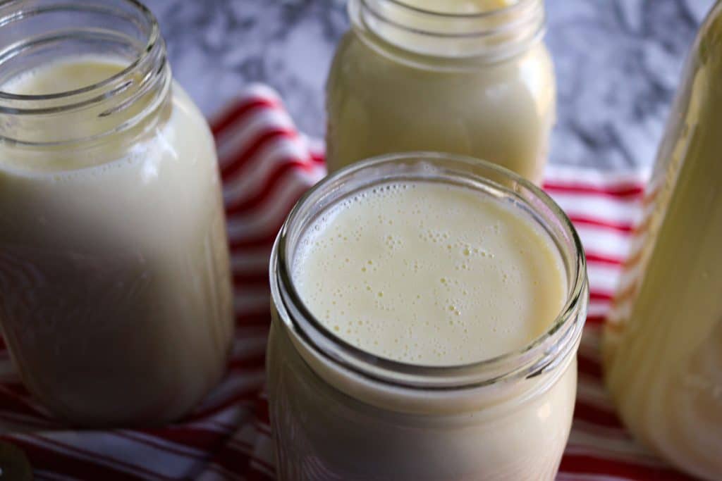 jars of custard on a red and white tea towel on a marble counter