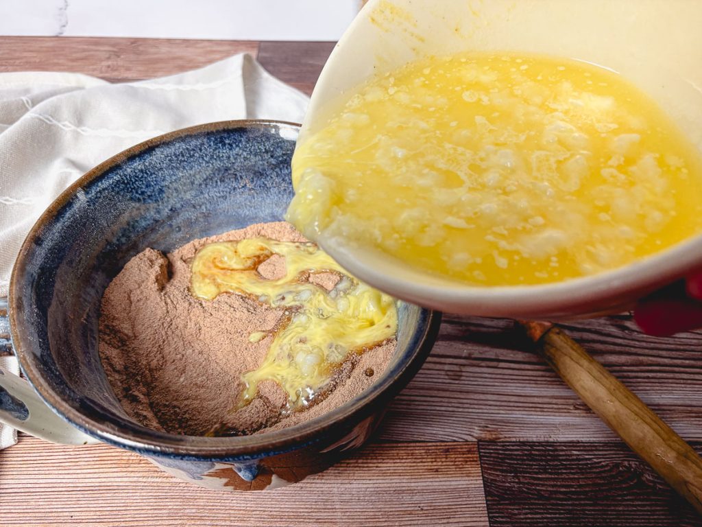 adding wet muffin ingredients to dry chocolate muffin ingredients