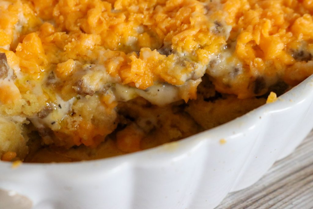 Gooey sourdough breakfast casserole with melted cheese and sausage gravy