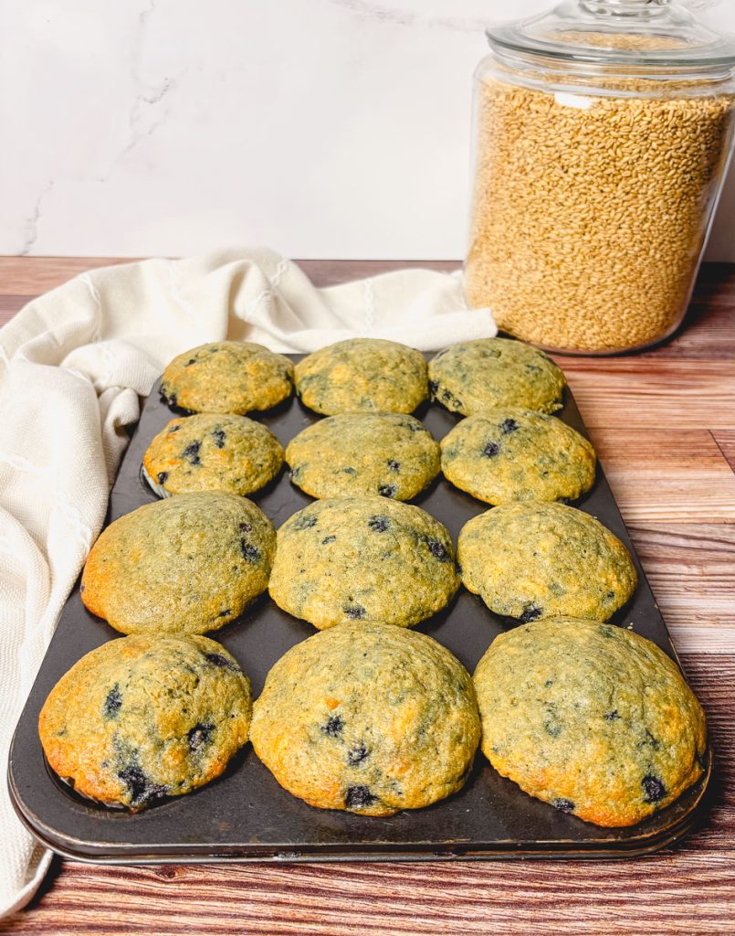 a full front view of a full muffin tray of blueberry muffins with fresh-milled flour