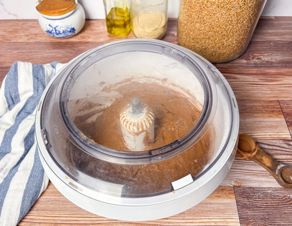 a bosch mixer bowl covered with the lid while brown bread roll dough rests