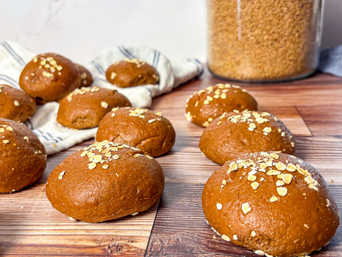 brown bread rolls with oats on a wooden counter