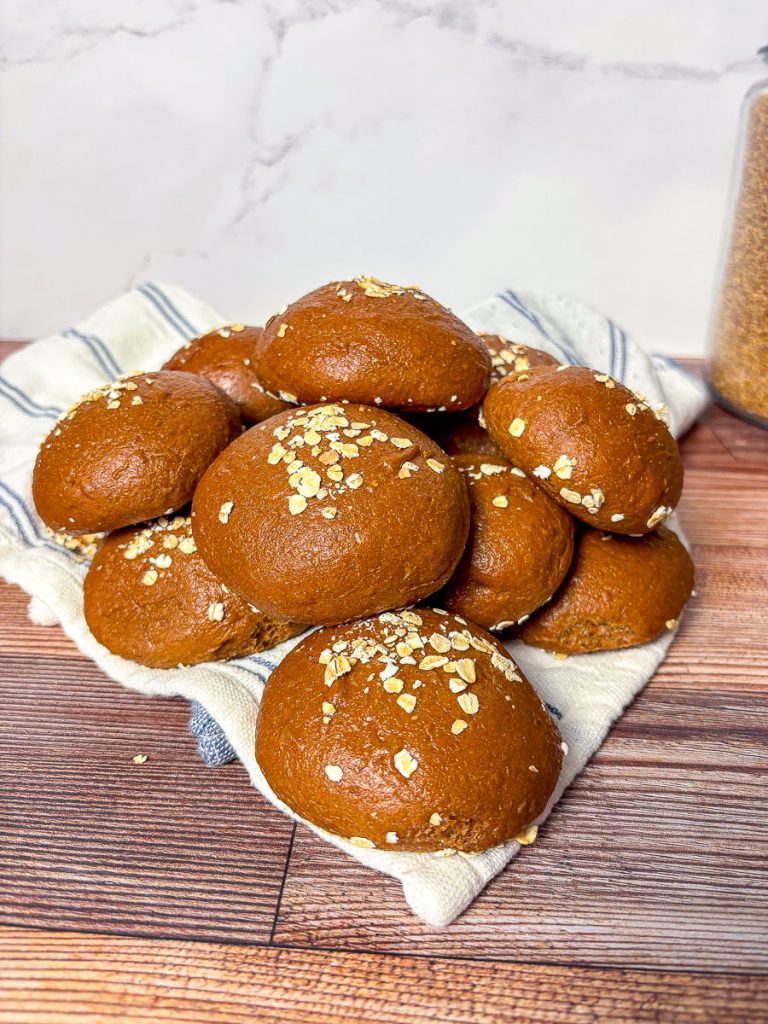 brown bread rolls with oat topping on a wooden counter